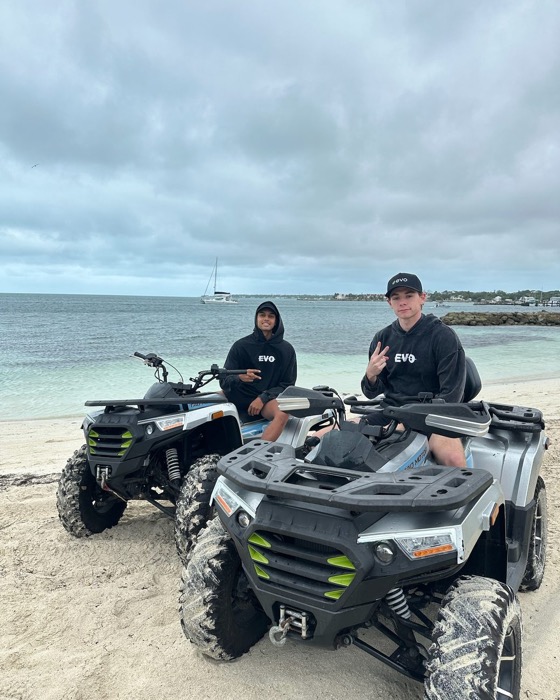 Evo teammates riding ATVs at the beach